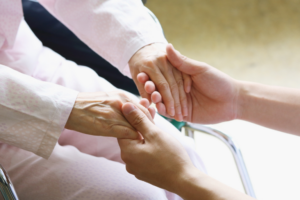 Hand holding elderly person’s hand